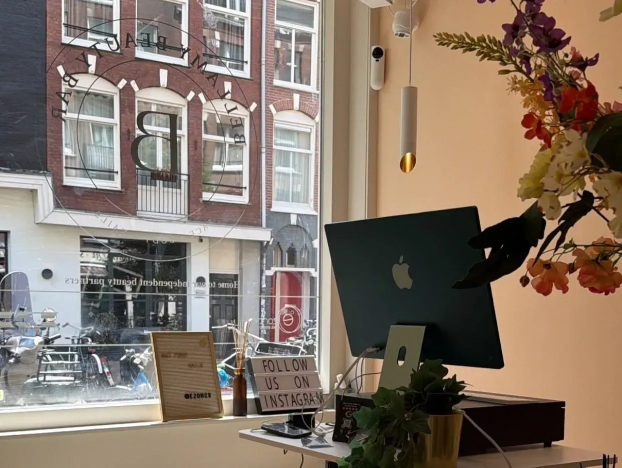 De balie met bloemen en uitzicht op de Bellamystraat